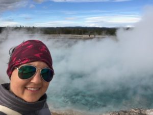 Julie K. with steaming pool in Yellowstone National Park