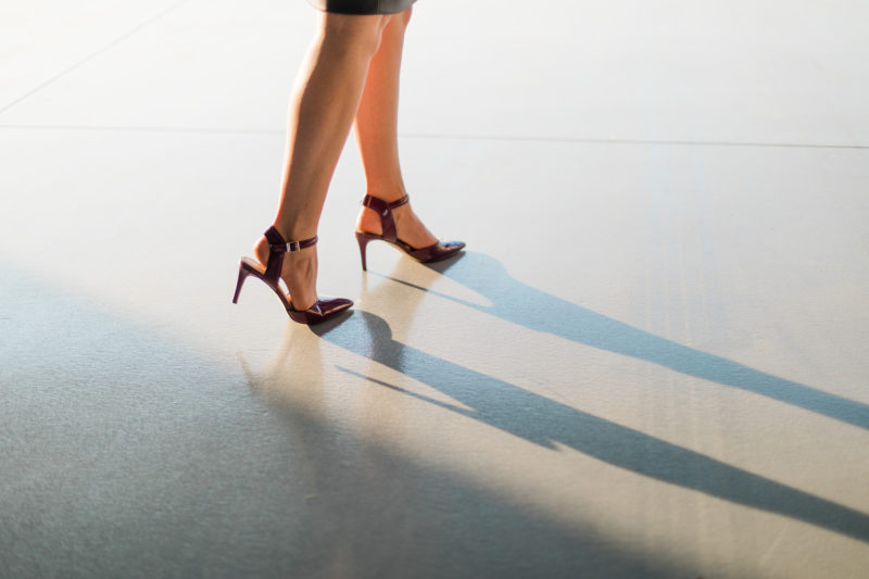 feet in plum stilettos walking with shadow in sunlight