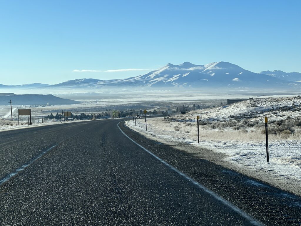 Lonely Highway and snow covered mountains in Nevada