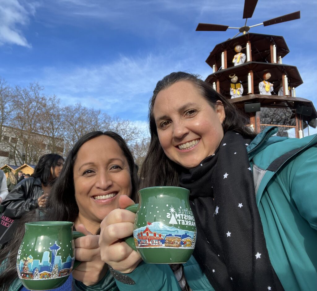Julie K and H with Seattle Christmas Market mugs and the Christmas Pyramid