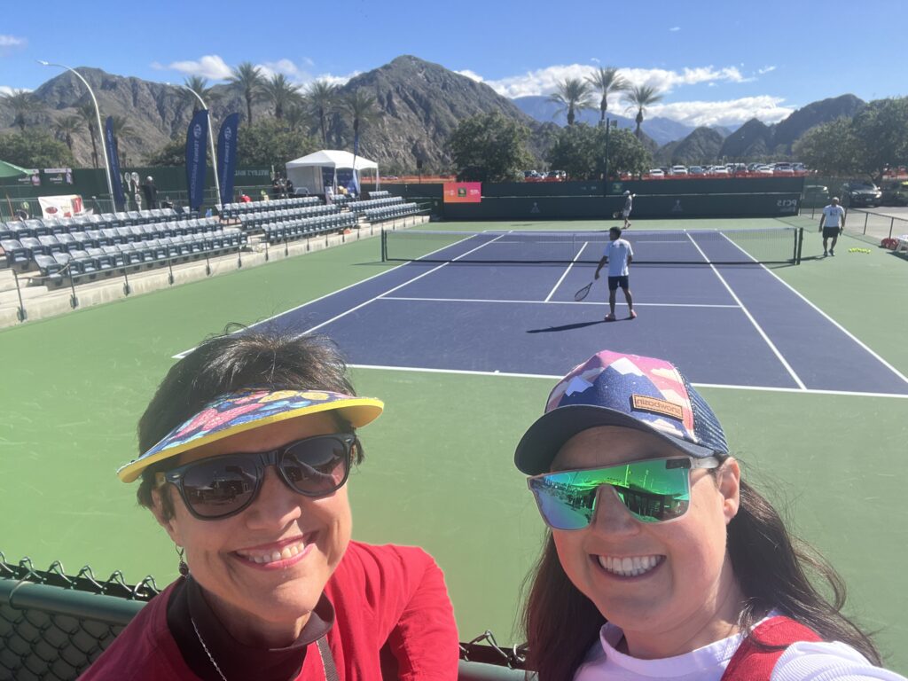 Julie K and her colleague overlooking a practice court at Indian Wells Tennis Garden