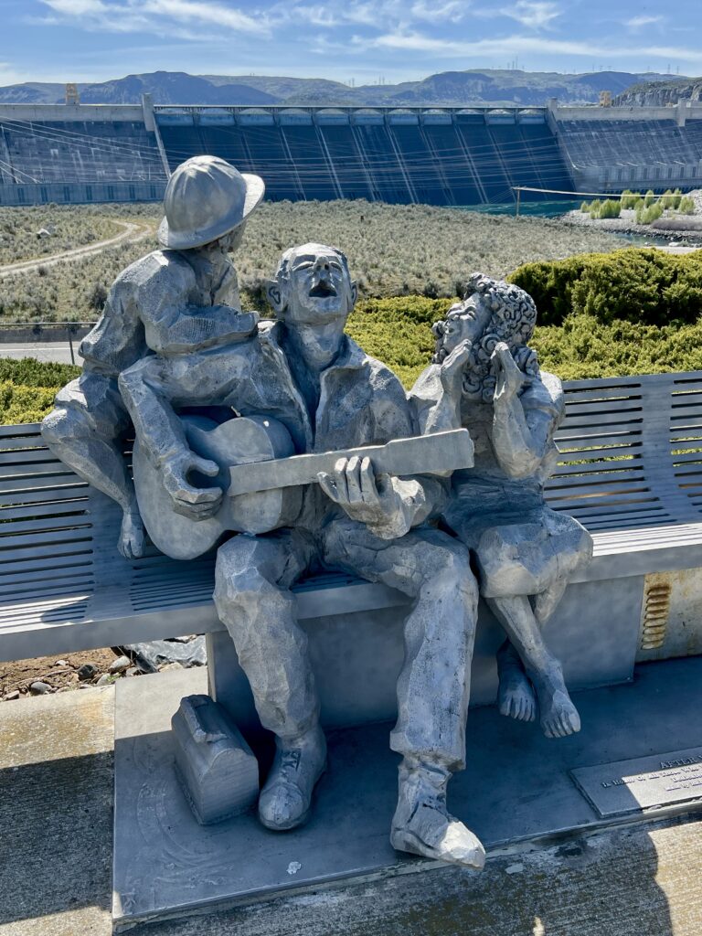 Statue with Grand Coulee Dam in the background